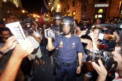 Un policía filma a manifestantes de la marcha "contra la brutalidad policial", ayer en la calle de Atocha.
