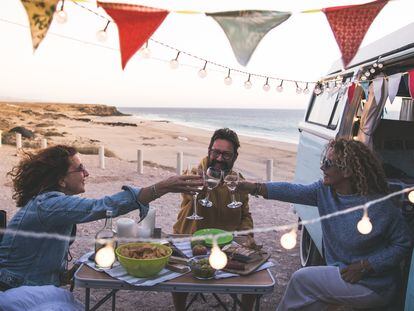 Unos amigos brindan en la playa.