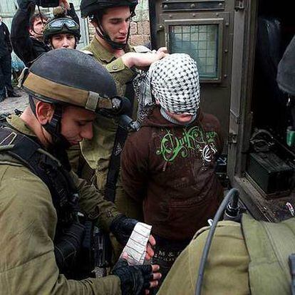 Soldados israelíes detienen a un palestino acusado de tirar piedras durante una manifestación en Hebrón.
