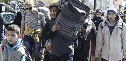 Un grupo de refugiados abandonan el viejo aeropuerto de Atenas, convertido en un campamento temporal.