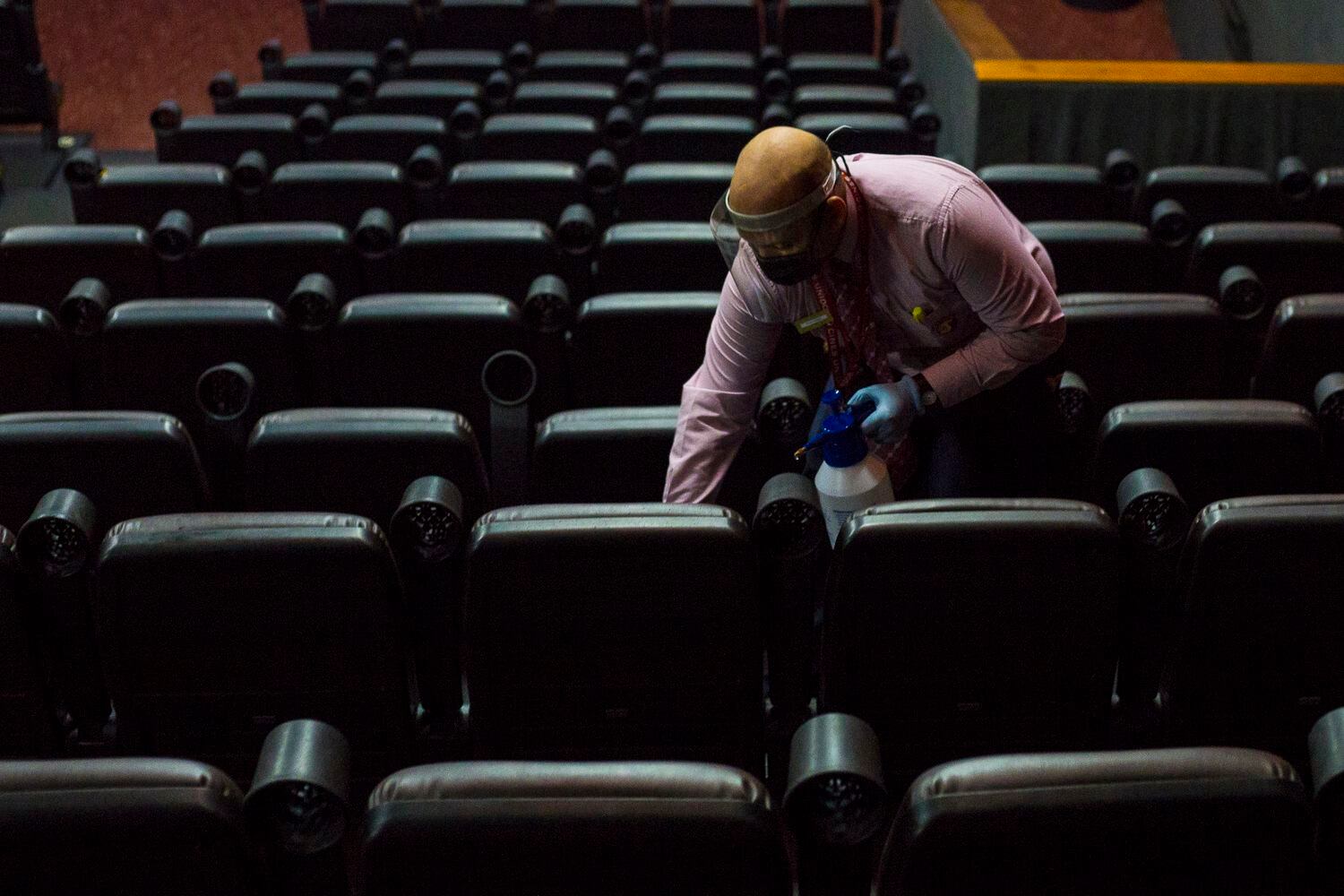 Un empleado limpia los asientos de una sala de un cine, el miércoles en Caracas.