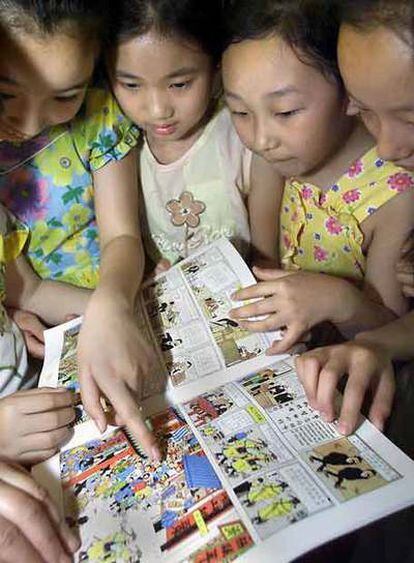 Un grupo de niñas chinas observa un cómic de Tintín durante una presentación en Pekín.