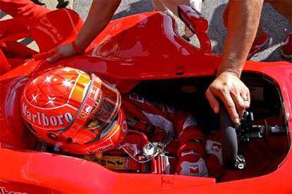 En la imagen, el piloto alemán Schumacher pone a punto su vehículo en los entrenamientos.