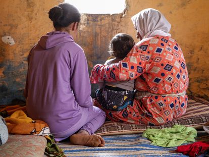 Sanaa, que fue violada desde los 11 años (izquierda), junto a su hijo, de un año, en brazos de su abuela, Jaiat, en su casa de Tiflet (Marruecos).