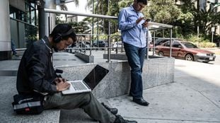 Dos personas tratan de conectarse a Internet en Caracas durante un apagón en abril de 2019.