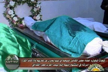 El cuerpo de un adulto envuelto en la bandera libia y de dos niños con sudario blanco, en Trípoli.