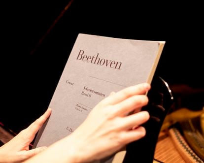 La investigadora Almudena Martín Castro abre uno de los libros con las partituras de Beethoven que han utilizado en su estudio.