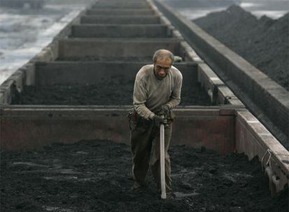 Un trabajador nivela una carga de carbón en un vagón de mercancías en Taiyuan, provincia de Shanxi.