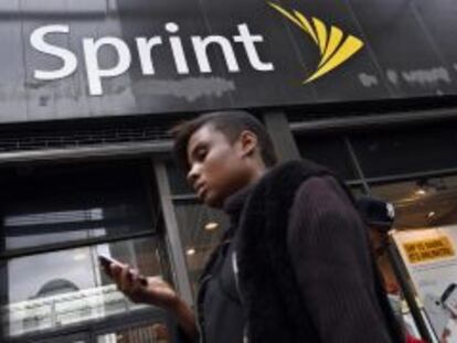 Una mujer utiliza su m&oacute;vil frente a una tienda de Sprint en Nueva York.