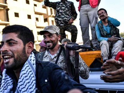 Miembros de las Fuerzas Democr&aacute;ticas Sirias celebran la reconquista de la ciudad siria de Raqa, arrebatada al Estado Isl&aacute;mico este martes.