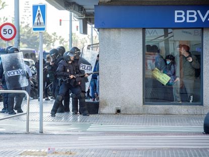 La policía se enfrenta a los trabajadores del metal en huelga mientras se esconden dentro de un banco, en Cádiz, el pasado 23 de noviembre.