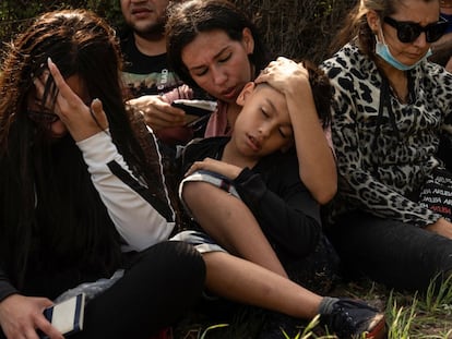 Una madre venezolana abanica a su hijo tras cruzar el Río Bravo.