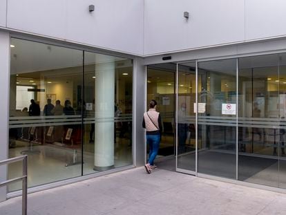 Una mujer entra en un centro de salud en el centro de Sevilla, donde varios pacientes guardan copla en su interior.