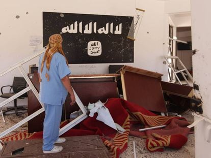 Un hombre observa los restos del ISIS en un edificio en Sirte, Libia.