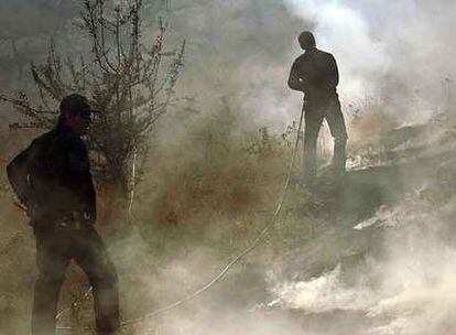 Miembros de los servicios de urgencias luchan contra uno de los incendios declarados en agosto en el Peloponeso.