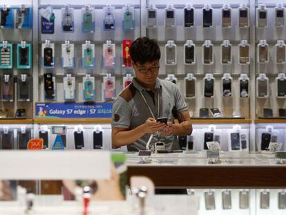 Un hombre mira un m&oacute;vil inteligente en una tienda de Samsung