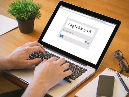 Un hombre escribiendo un código captcha en un ordenador portátil.