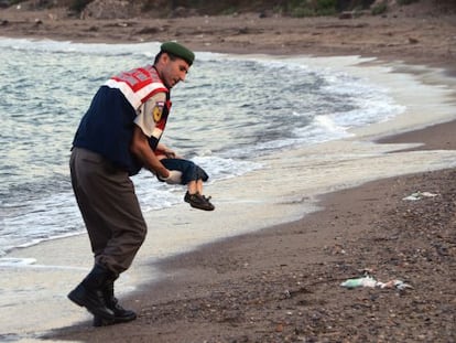 Un polic&iacute;a recoge el cad&aacute;ver de un ni&ntilde;o en una playa de Turqu&iacute;a.