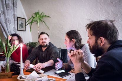 Monika Szewczyk, Tomasz Kosiek e Ignacy Jozwiak, en un restaurante de Przmysl, escuchando a Elizbieta Mirga-Wójtowicz, una investigadora polaca de etnia gitana (centro), mientras planean actividades para apoyar a la comunidad gitana que huye de Ucrania por la frontera polaca.  Los cuatro trabajan en el Centro de Investigación de la Migración, perteneciente a la Universidad de Varsovia, y colaboran con el Instituto Europeo de Arte y Cultura Gitana (ERIAC), con sede en Berlín.