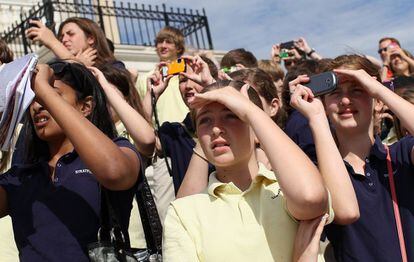 Un grupo de escolares observa el vuelo del 'Discovery' sobre el Boeing 747 en el Capitolio.