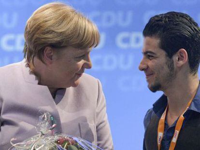 La canciller alemana, Angela Merkel agradece al refugiado sirio Mohammad Hussan su discurso durante una conferencia regional de la CDU.