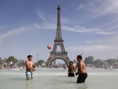Jóvenes junto a la Torre Eiffel durante la ola de calor de la semana pasada.