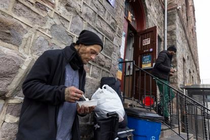 Daniel come su almuerzo en la puerta de Prevention Point, un centro en el que entregan Narcan, agujas y comida a drogodependientes.