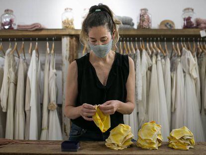 Ruth Fernández, propietària d'una botiga de vestits de núvia, s'ha reinventat fent mascaretes de tela al seu taller.