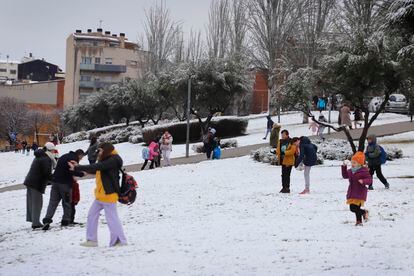 Un grupo de niños juega con la nieve en un parque de Terrassa, este lunes. 