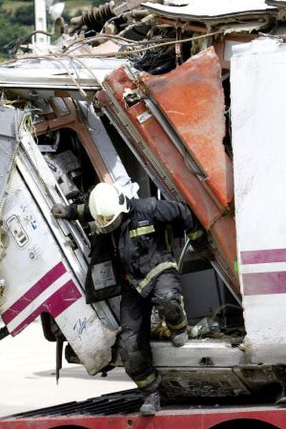 Un bombero trabaja en uno de los vagones del tren siniestrado en Santiago.