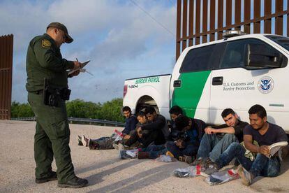 Un agente de la Patrulla Fronteriza detiene a un grupo de inmigrantes ilegales en la frontera entre México y Estados Unidos.