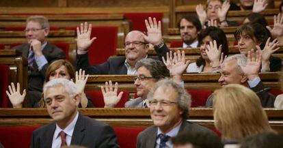 Los diputados del PP alzan las manos en el momento de la votación.