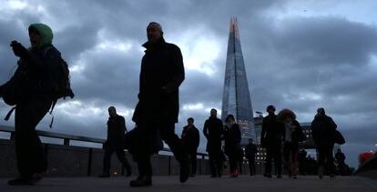Varias personas caminan ayer por el distrito financiero de Londres.