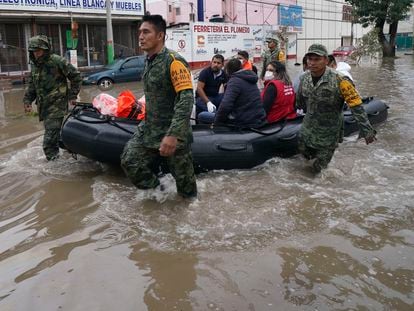 Soldiers move health workers on an inflatable boat on a flooded street in Tula, Hidalgo state, Mexico, Tuesday, Sept. 7, 2021. Torrential rains in central Mexico suddenly flooded a hospital in Tula, killing more than a dozen patients, with about 40 other surviving as waters rose swiftly and flooded the public hospital. (AP Photo/Marco Ugarte)
