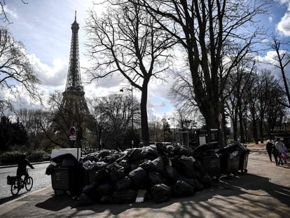 Peatones y ciclistas pasan junto a una montaña de basura en los alrededores de la Torre Eiffel este miércoles.