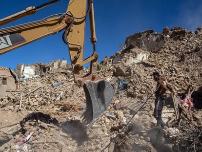 Una excavadora retira escombros de un edificio derrumbado por el terremoto en Douzrou (Marruecos).