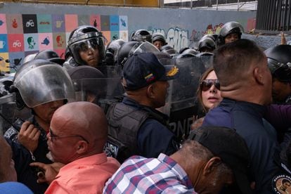 Policías y ciudadanos forcejean durante la protesta.