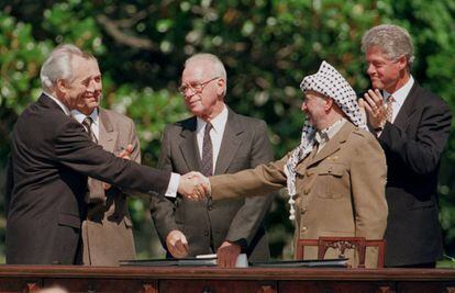 El ministro de Exteriores de Israel Simon Peres (i) saluda al presidente de la Organización para la Liberación de Palestina, Yasir Arafat (d), durante la firma del acuerdo de paz para Oriente Medio de Washington, en 1993.