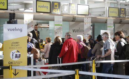 Pasajeros esperan para embarcar sus maletas en Vueling.