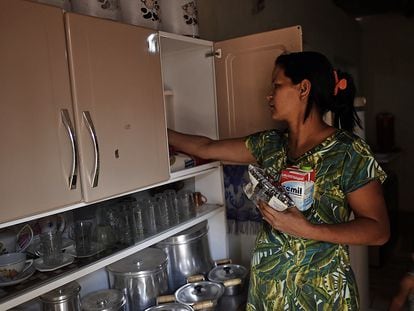 Carla dos Santos acomoda alimentos en la alacena de su casa en Mateus Leme, región metropolitana de Belo Horizonte.