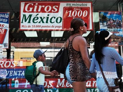 Una familia camina frente a una tienda que se especializa en llamadas y viajes a Latinoamérica, en agosto de 2016.