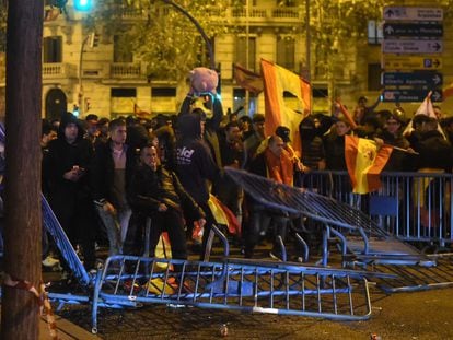 Varios manifestantes tirando las vallas de seguridad durante las protestas la noche del 18 de noviembre frente a la sede del PSOE en Ferraz.