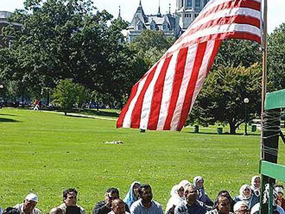 Un grupo de fieles sigue una ceremonia islámica en un parque de Connecticut.