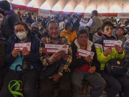 Un grupo de beneficiarios muestra sus tarjetas de la Pensión del Bienestar, en la ciudad de Toluca.