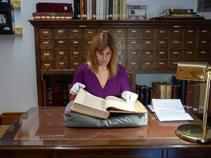 La investigadora Ane Galindo sostiene uno de los libros censurados de la Biblioteca Histórica de Santa Cruz, en Valladolid.