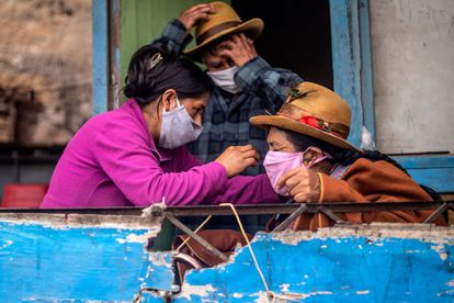 Una familia en Pamplona Alta, a las afueras de Lima (Perú), se prepara para salir con mascarillas.