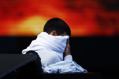 Djokovic, cubierto por una toalla durante un descanso.