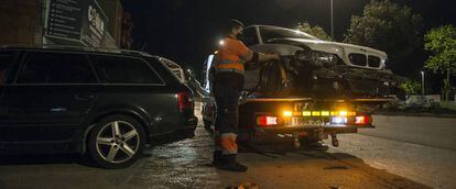 Un operario de grúa recoge un vehículo accidentado en Girona.