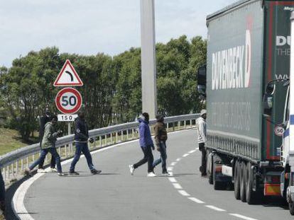 Varios inmigrantes cruzan una v&iacute;a cerca de la entrada del eurot&uacute;nel.