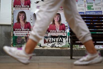 A neighbor from Maracena passes in front of electoral posters in the town of Granada.